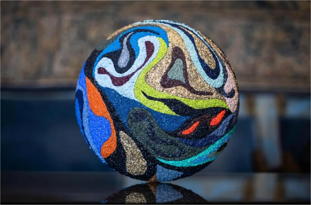 Arca de la Alianza, Pep Marchegiani — La sfera scultorea rivestita di materia cromatica: un mosaico di tessere ricavate da scorie industriali nere, in un dialogo fra arte e rigenerazione.